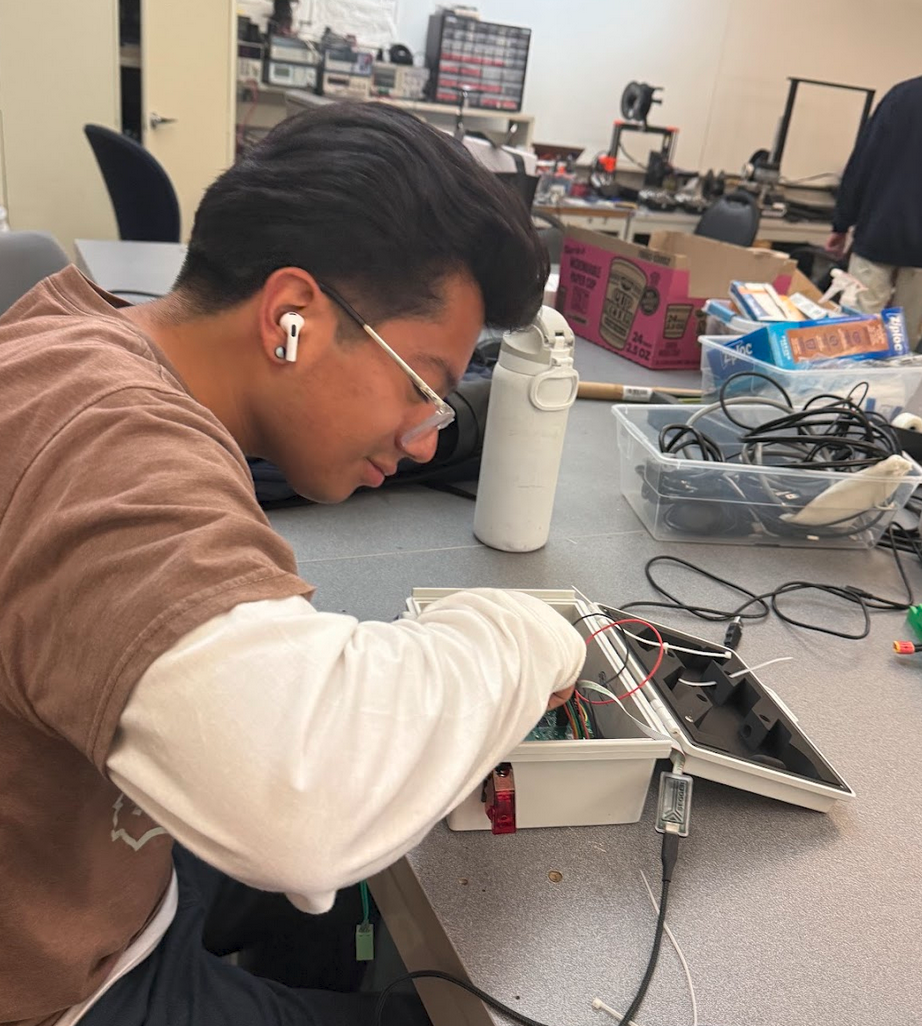 Emmanuel working at a bench with electronics